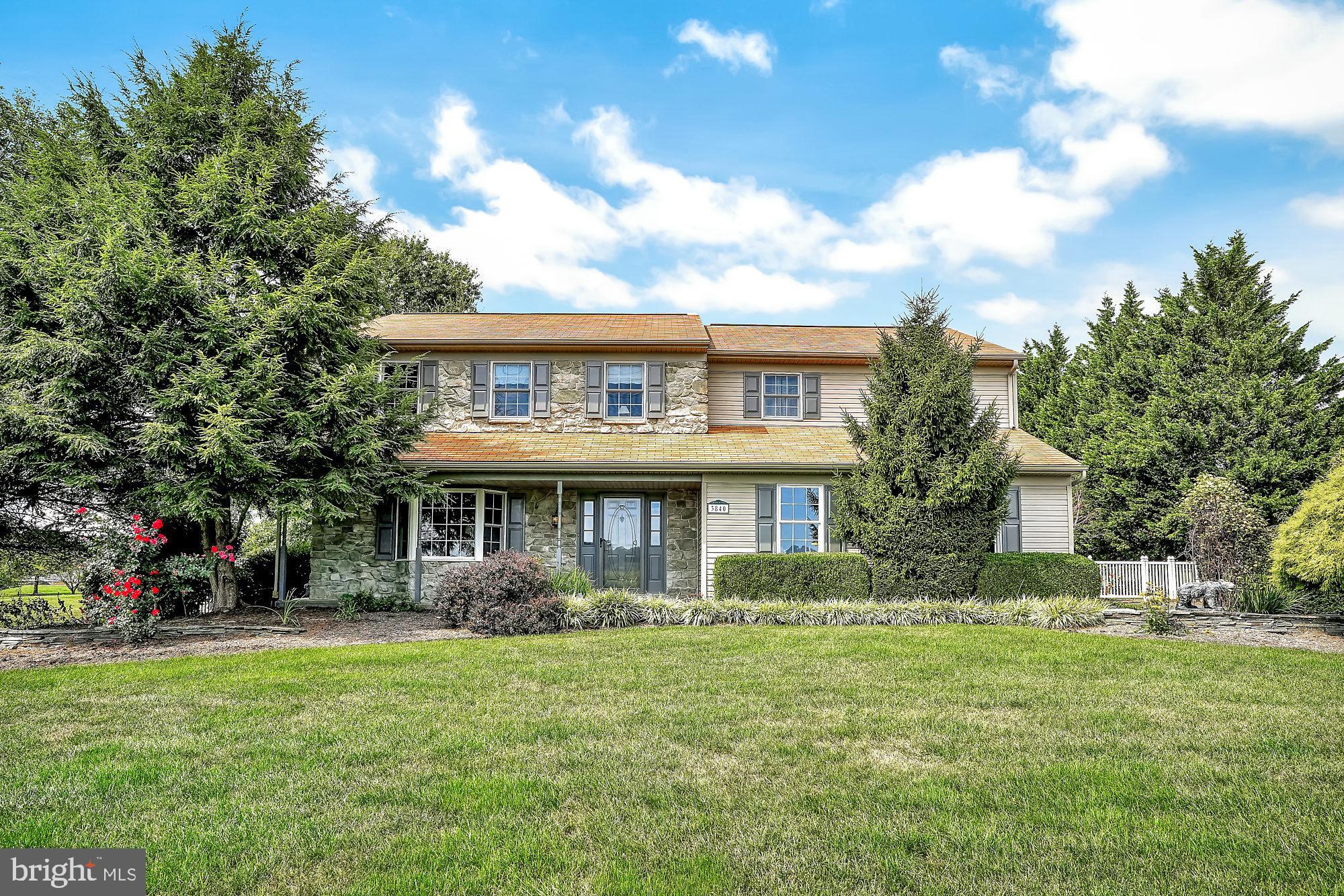 a front view of house with yard and green space