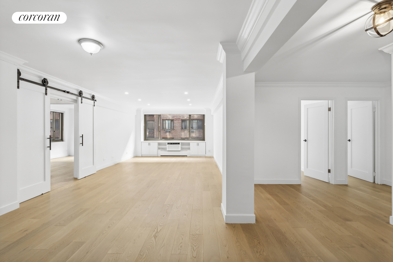 a view of a big room with wooden floor and windows