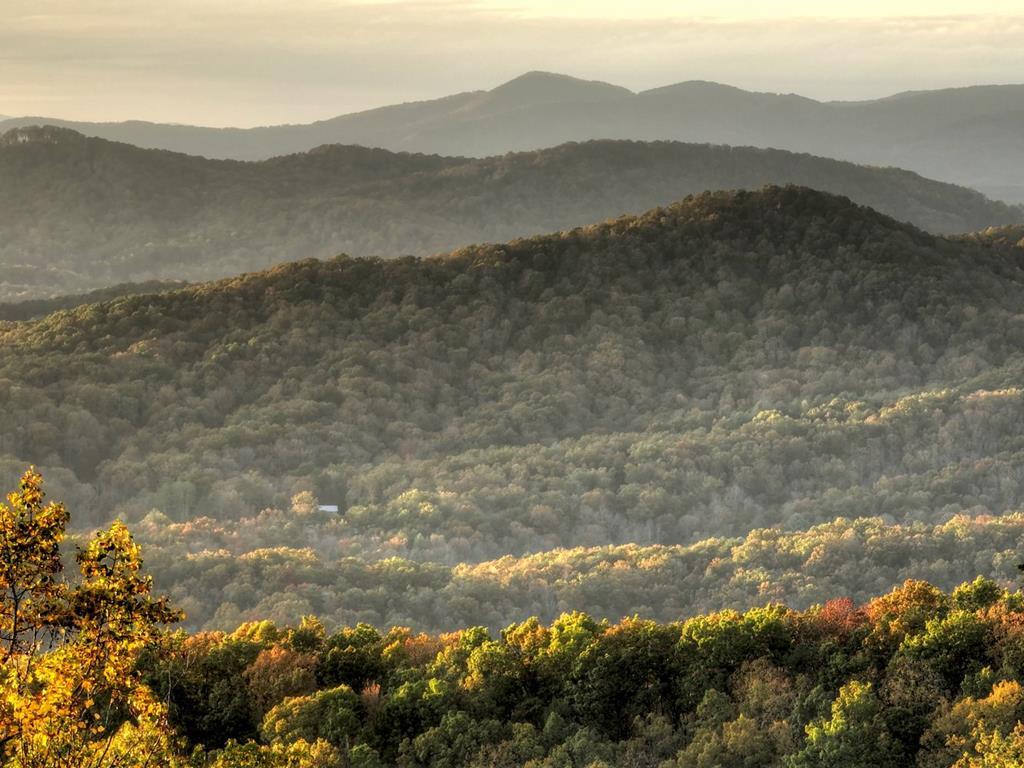 a view of mountain with sunset in background