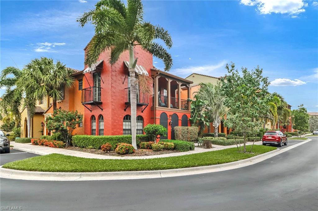 a front view of multi story residential apartment building with yard and green space