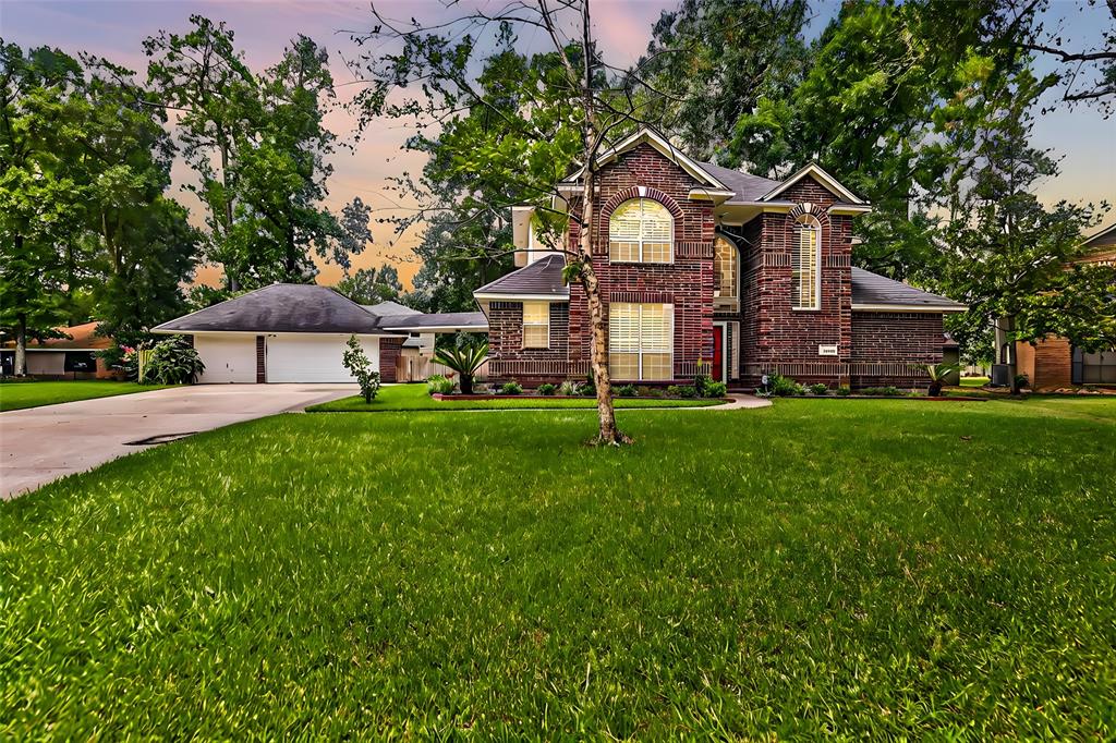 a front view of a house with a yard and trees