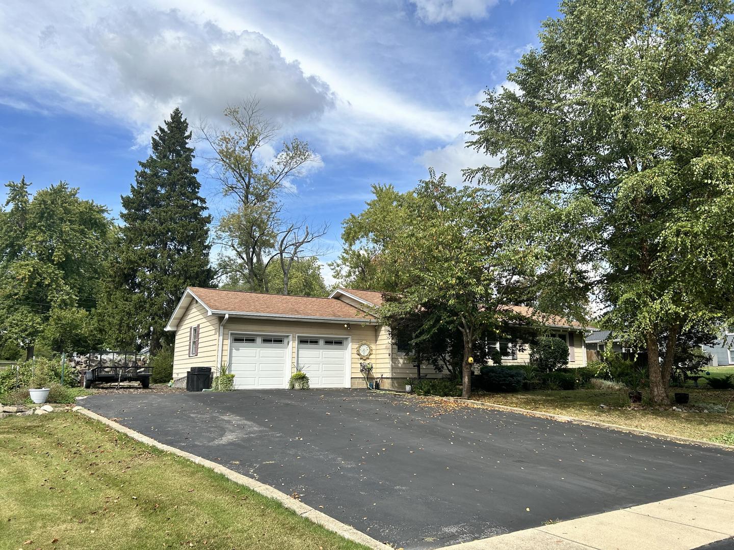 a view of a house with a yard and large trees