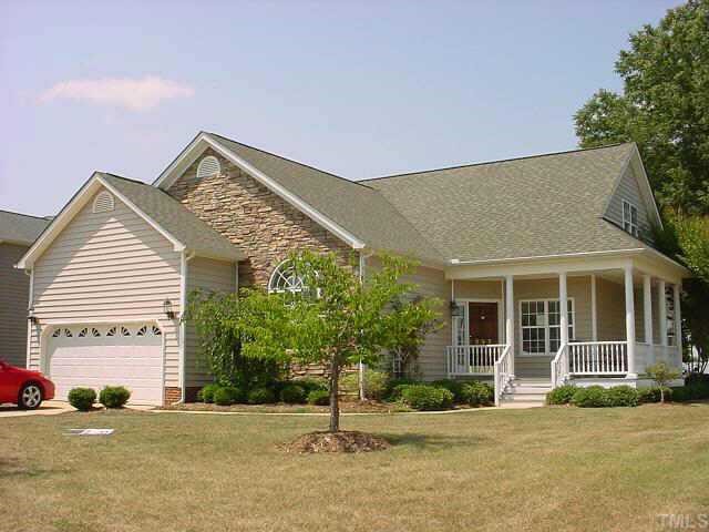 a front view of a house with a garden and plants