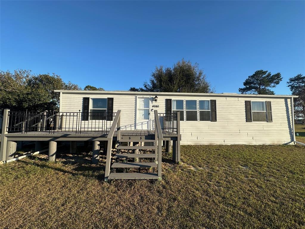 a view of a house with wooden deck and furniture