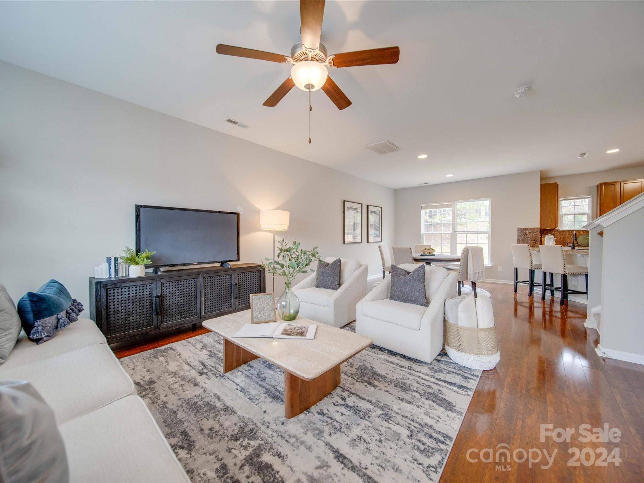 a living room with furniture a rug and a flat screen tv