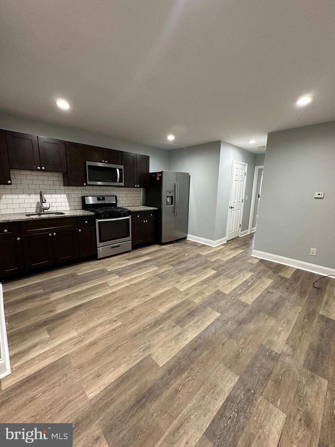 a large kitchen with kitchen island a sink stainless steel appliances and cabinets