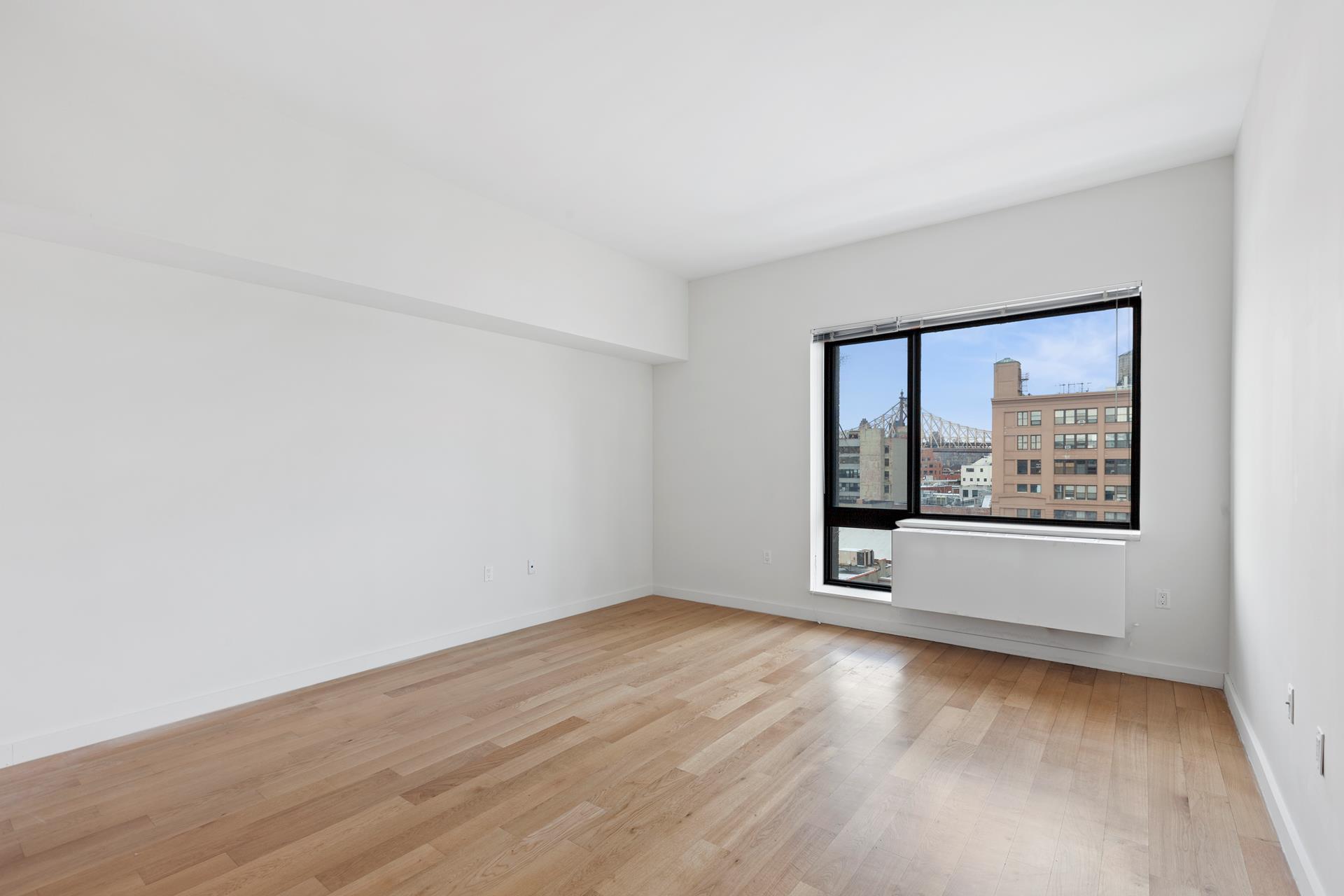 a view of a big room with wooden floor and windows