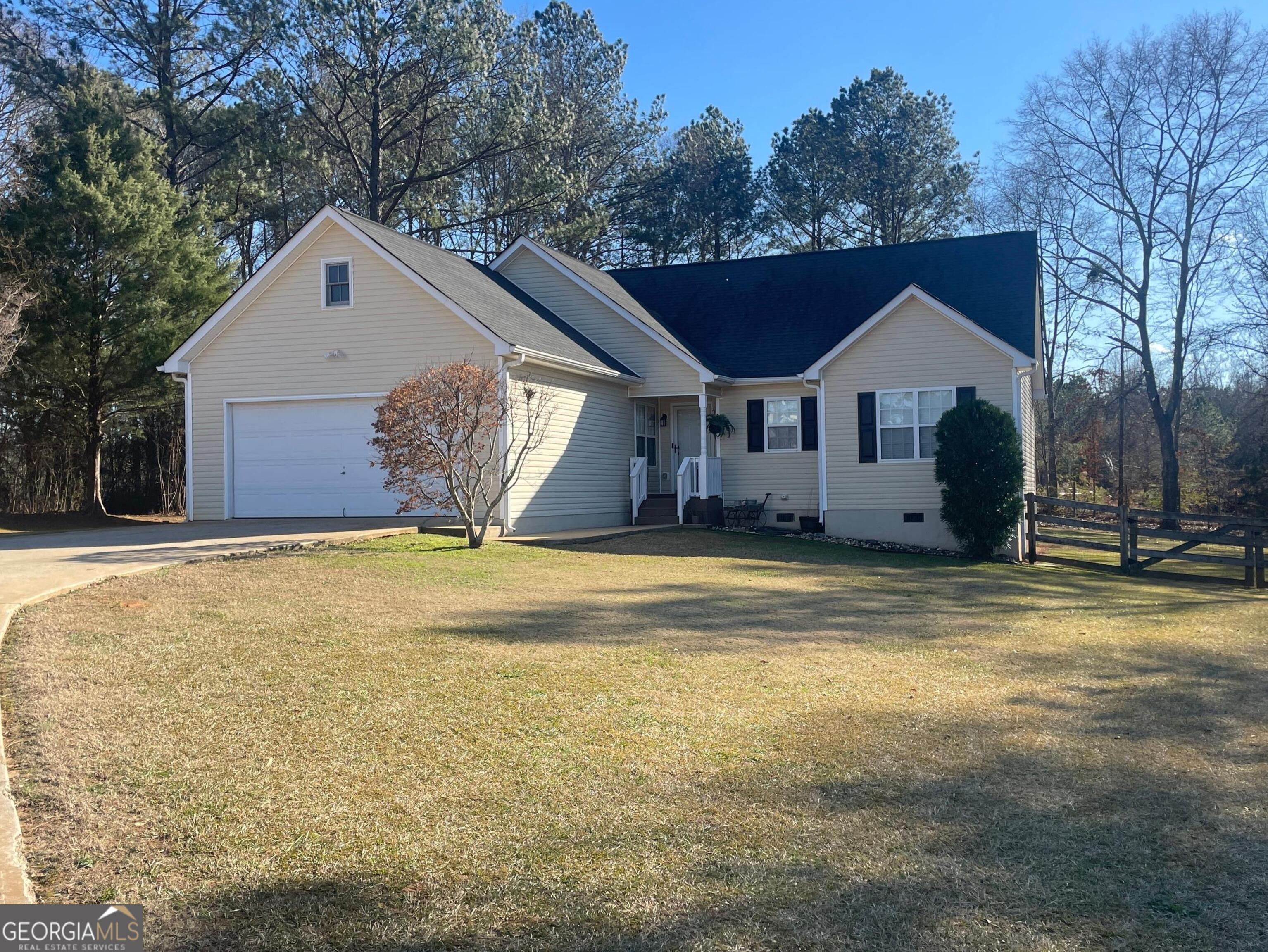 a front view of house with yard and trees in the background