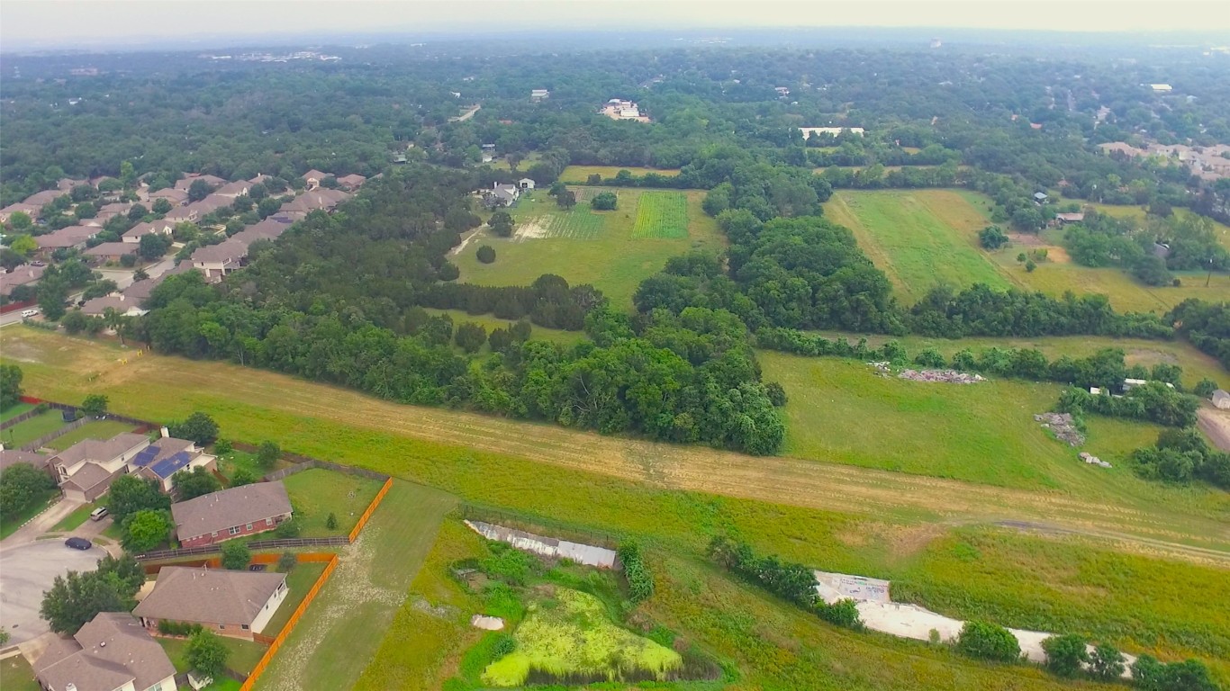 an aerial view of residential houses with outdoor space and lake view