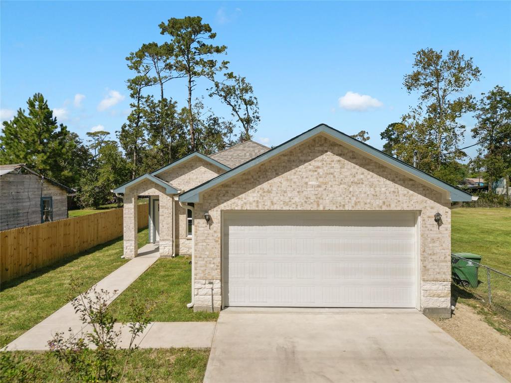 a view of house with a yard and a garage