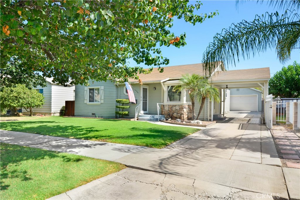 a front view of a house with a garden and palm trees