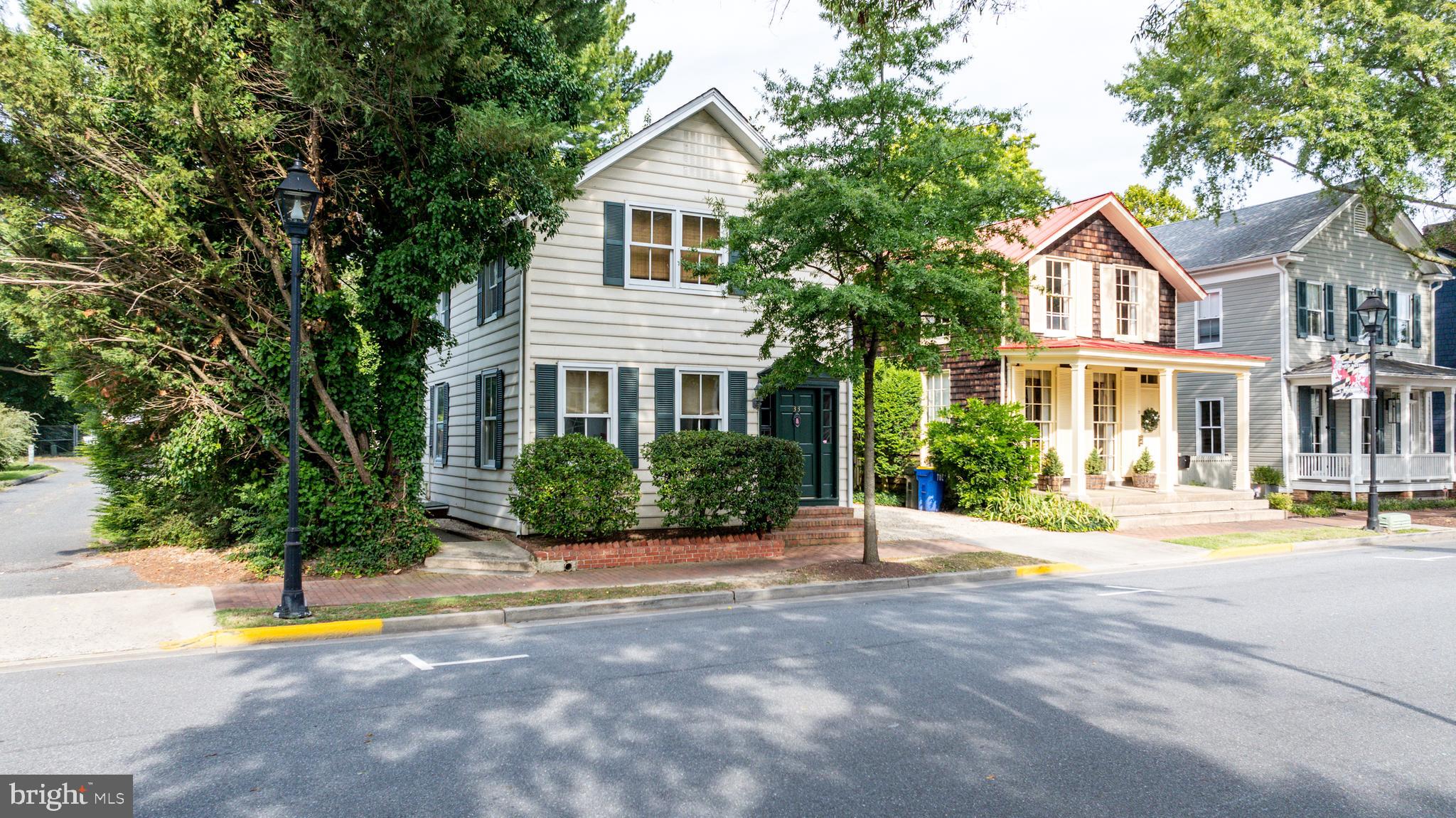 a front view of a house with a yard and potted plants