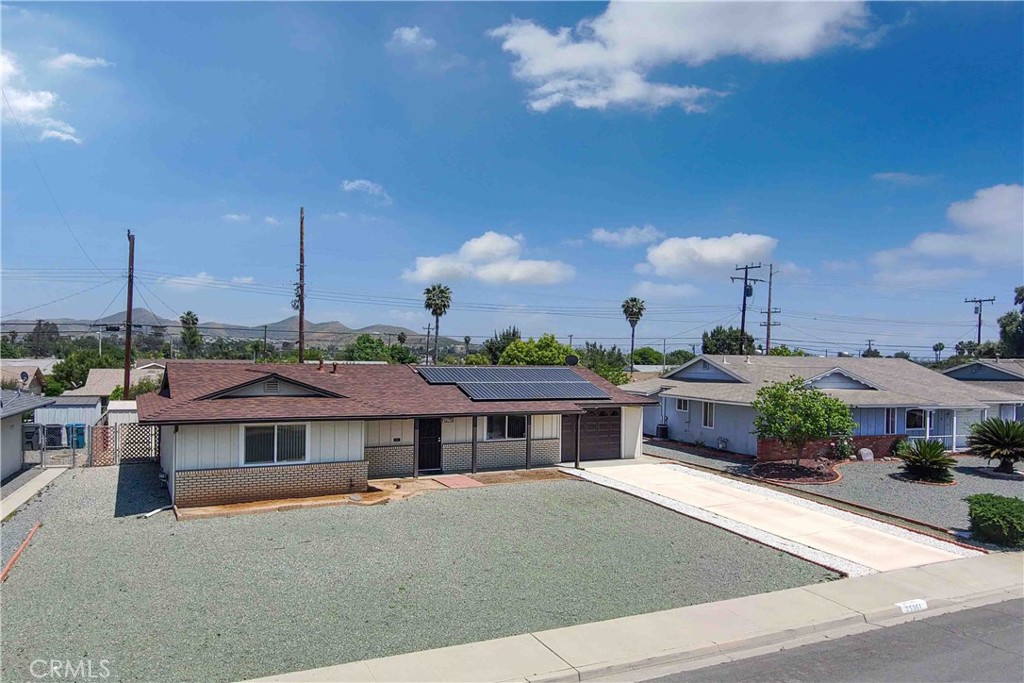 a front view of a house with a garden and a car parked