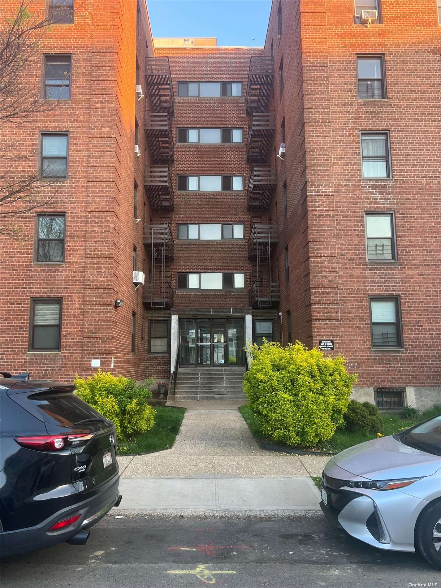 a couple of cars parked in front of brick building