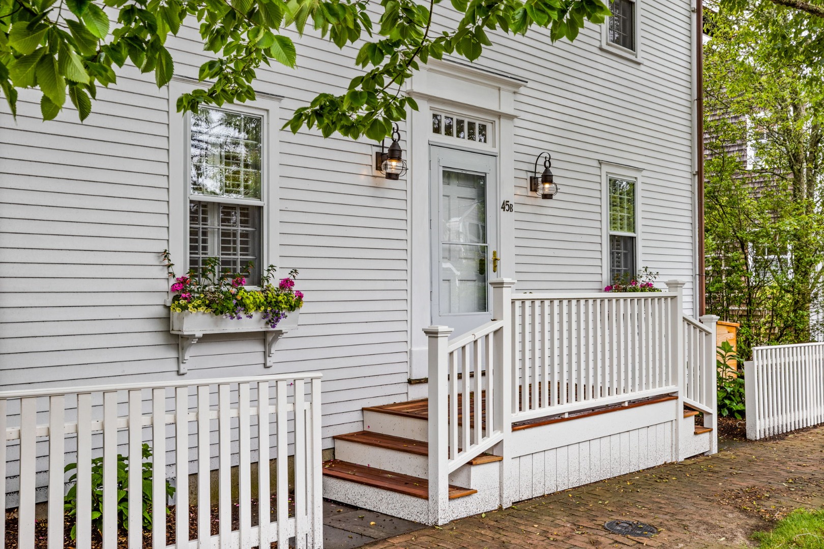 a view of a house with a small yard and wooden fence