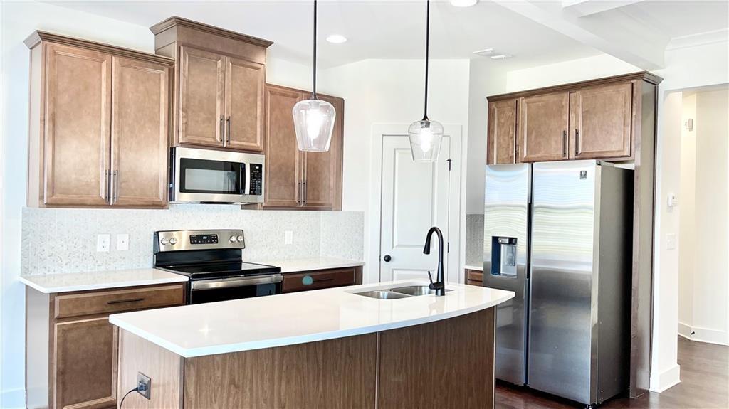 a kitchen with stainless steel appliances a refrigerator sink and microwave