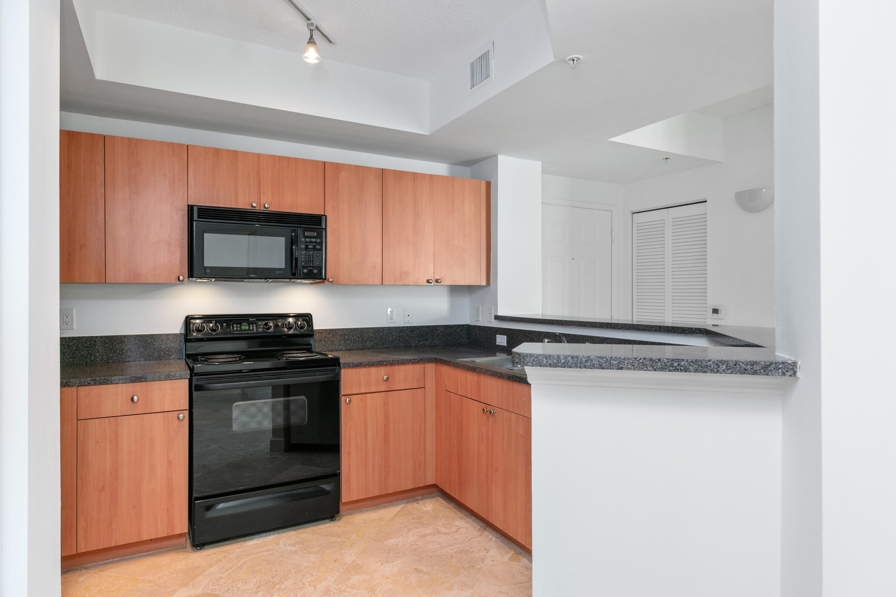 a kitchen with stainless steel appliances granite countertop a stove and a microwave