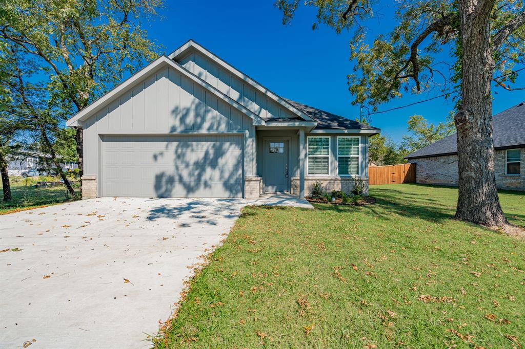 a view of a house with backyard and a tree