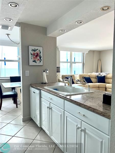 a living room with granite countertop lots of white furniture and window