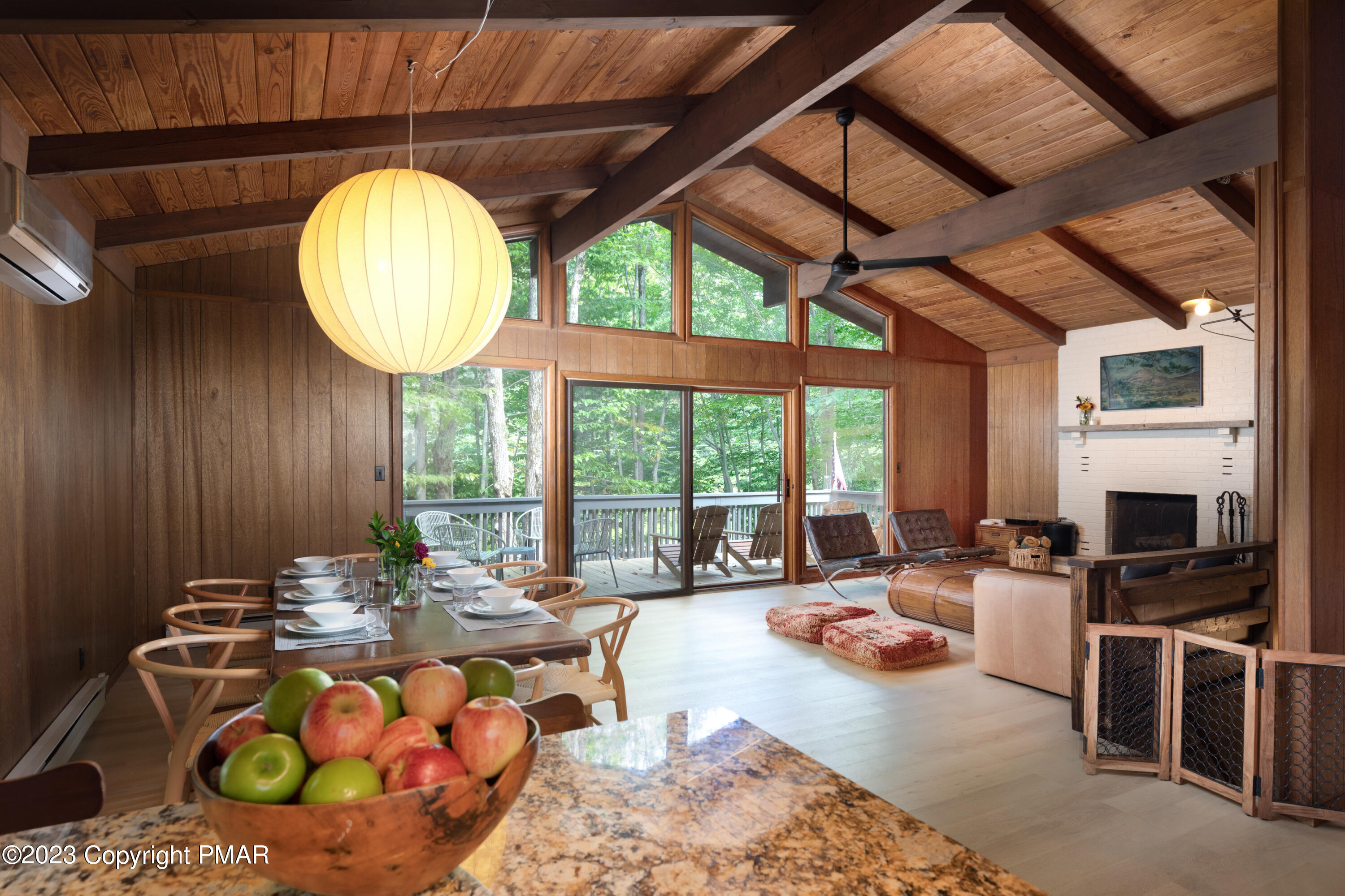 a living room with furniture a fireplace and a dining table with wooden floor