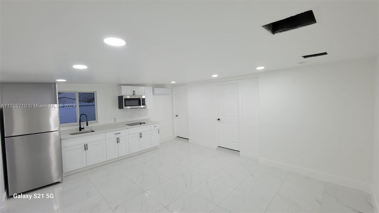 a kitchen with granite countertop a refrigerator and a sink