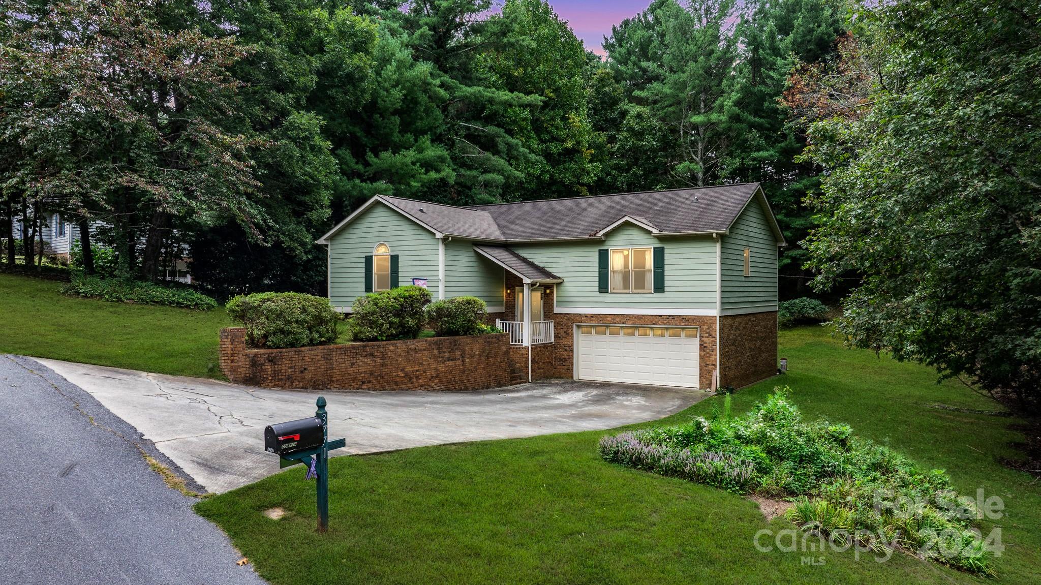 a front view of a house with a yard and potted plants