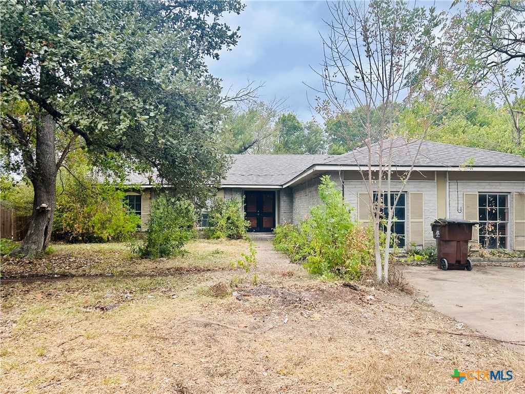 a front view of a house with a yard and potted plants