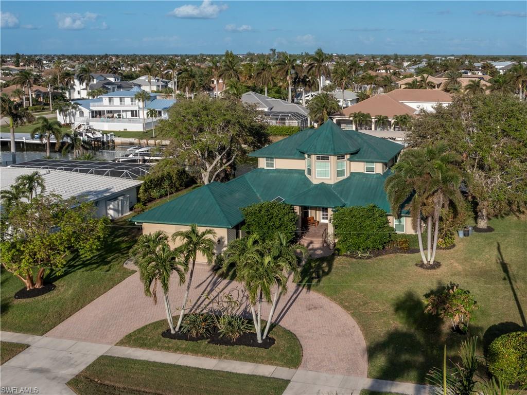 an aerial view of a house with a yard and lake view in back