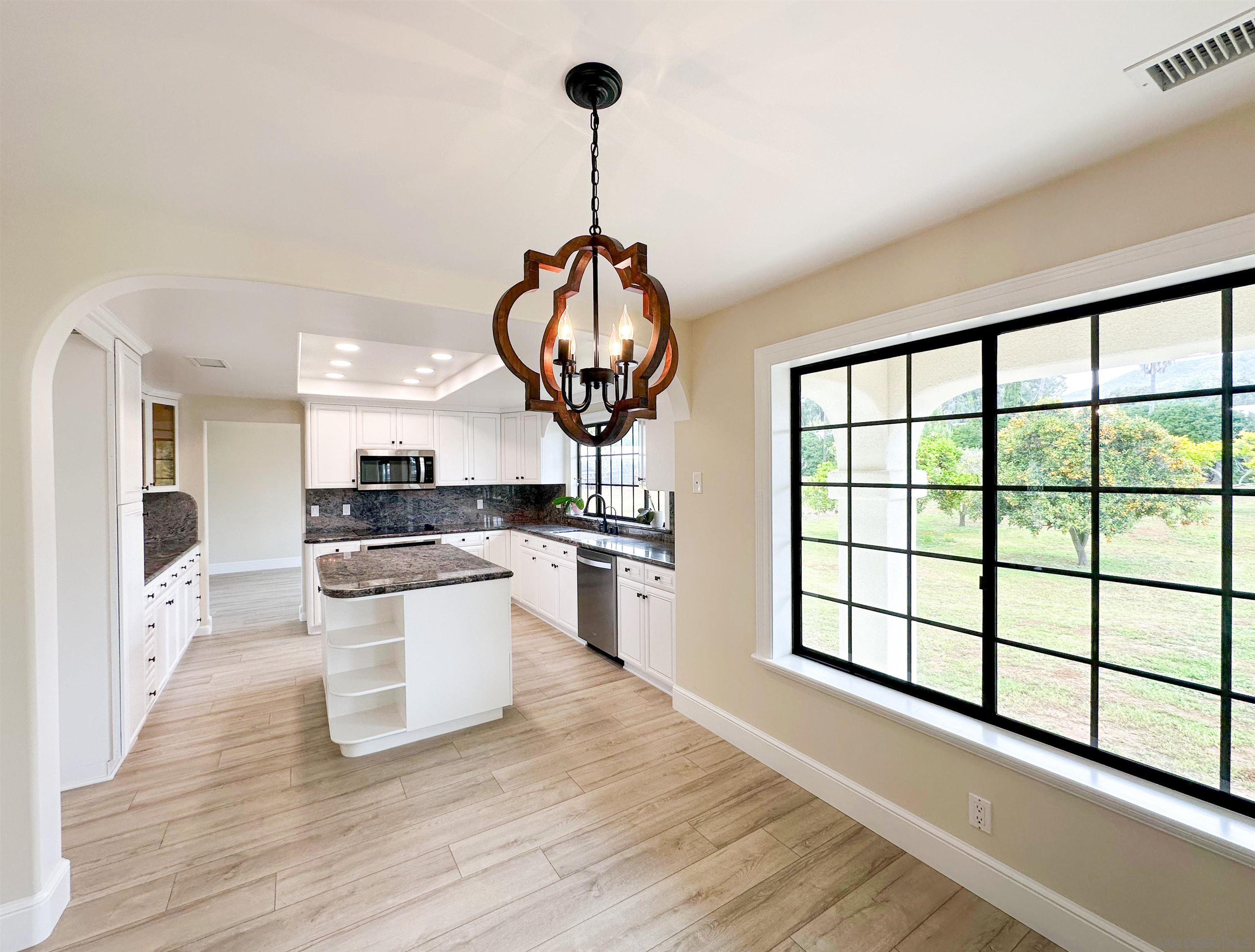 a kitchen with stainless steel appliances granite countertop a stove a sink and a wooden floors