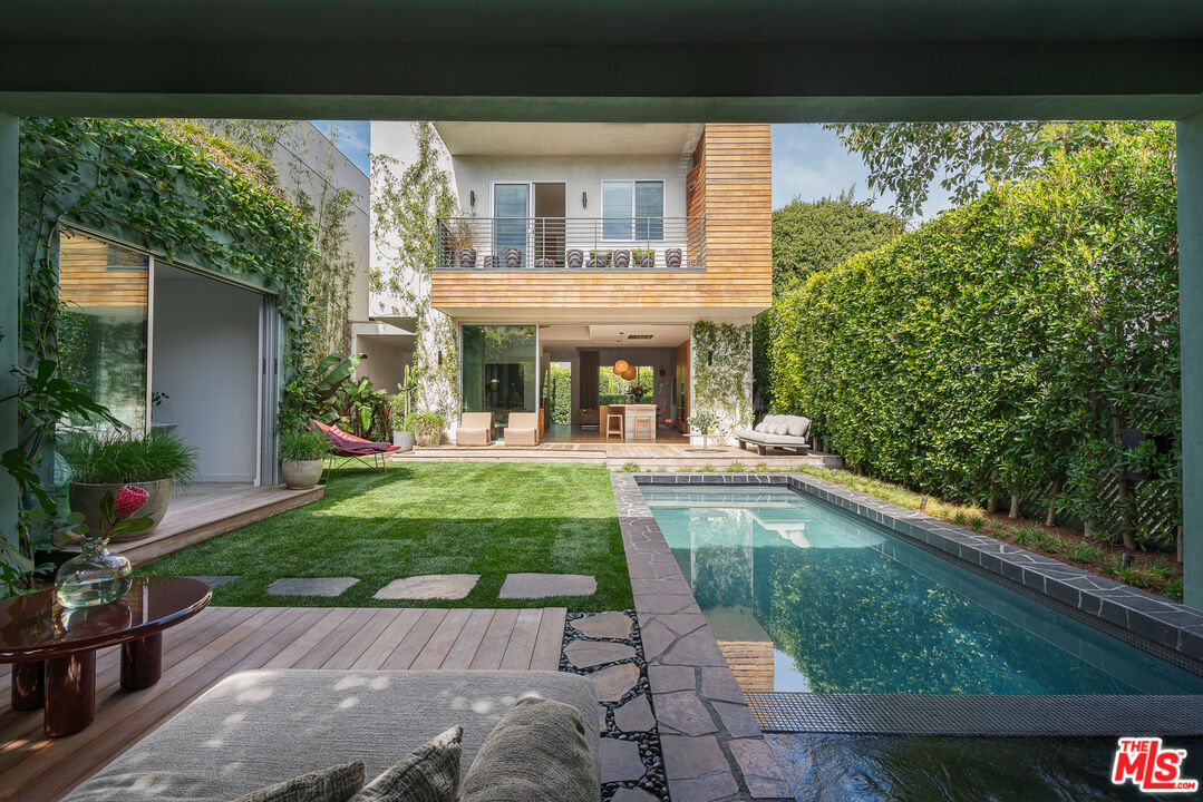 a view of house with swimming pool and outdoor seating