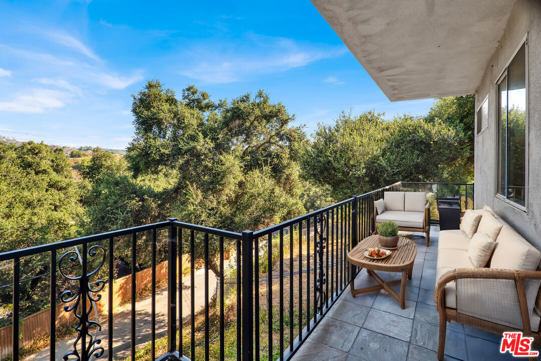 a balcony with wooden floor and outdoor seating