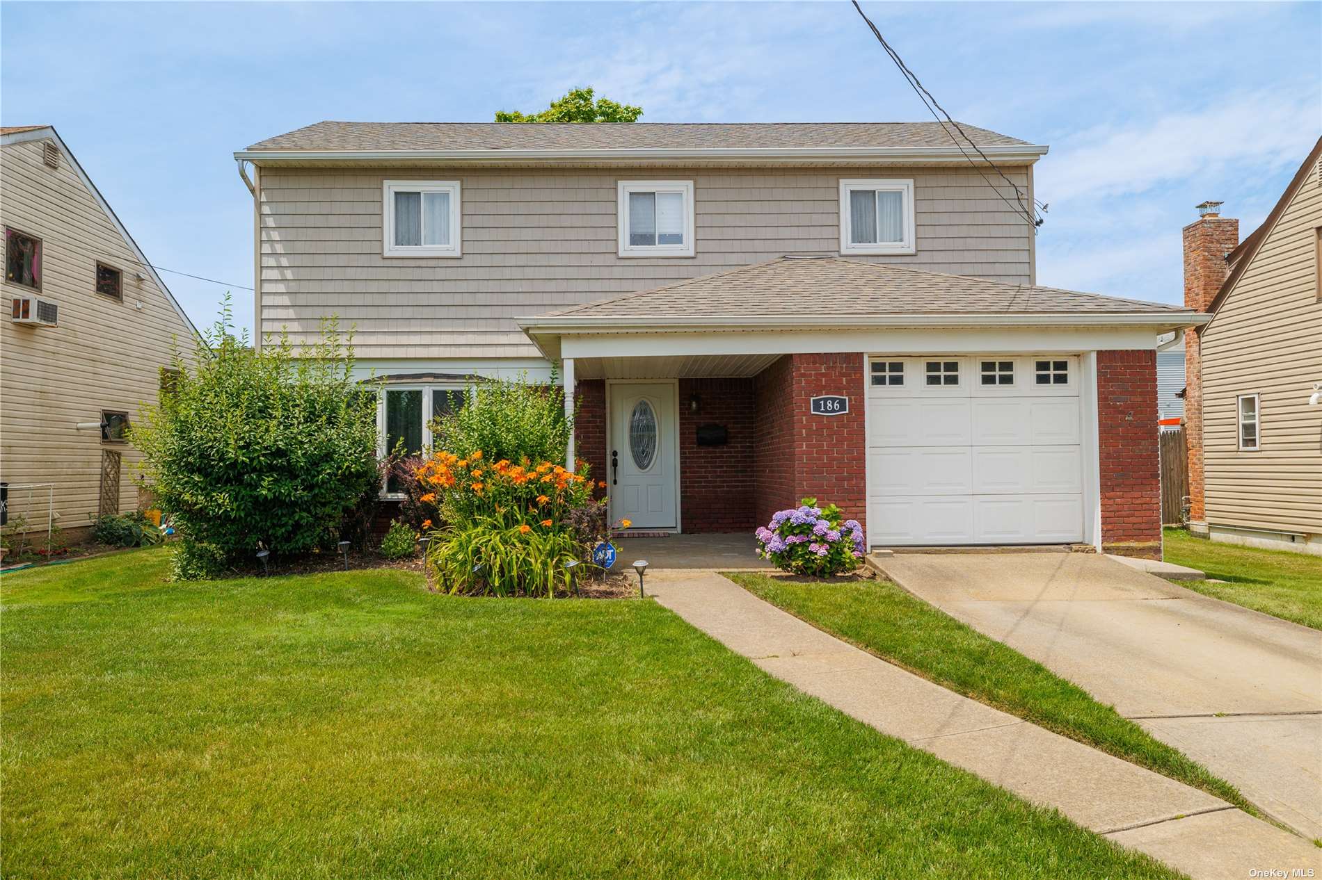 a front view of a house with a garden and yard