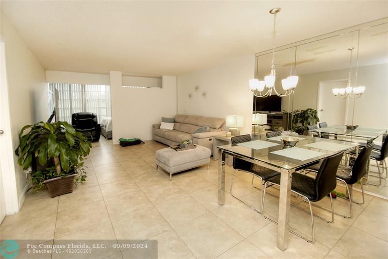 a living room with furniture a chandelier and a table