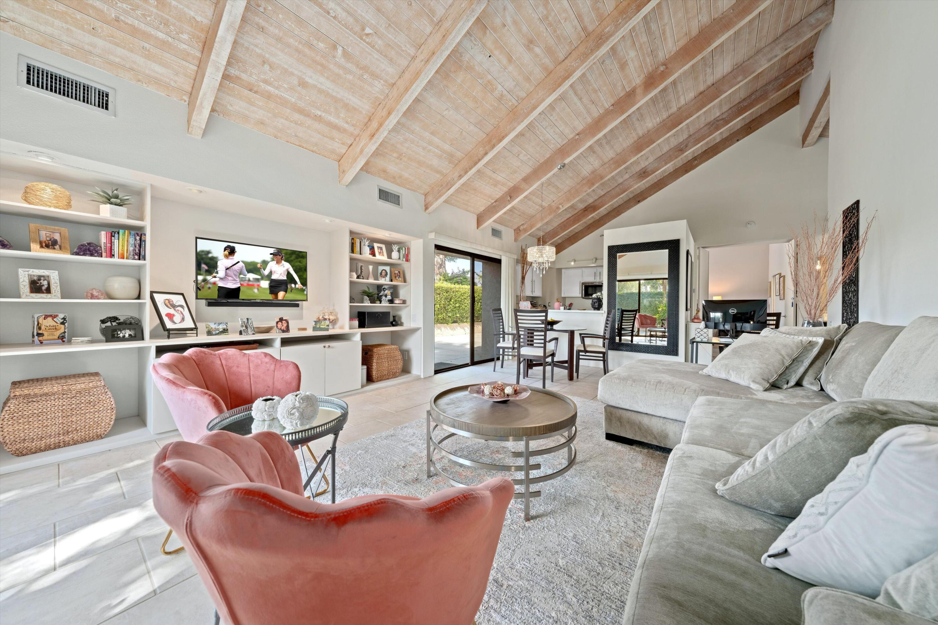 a living room with furniture kitchen view and a large window