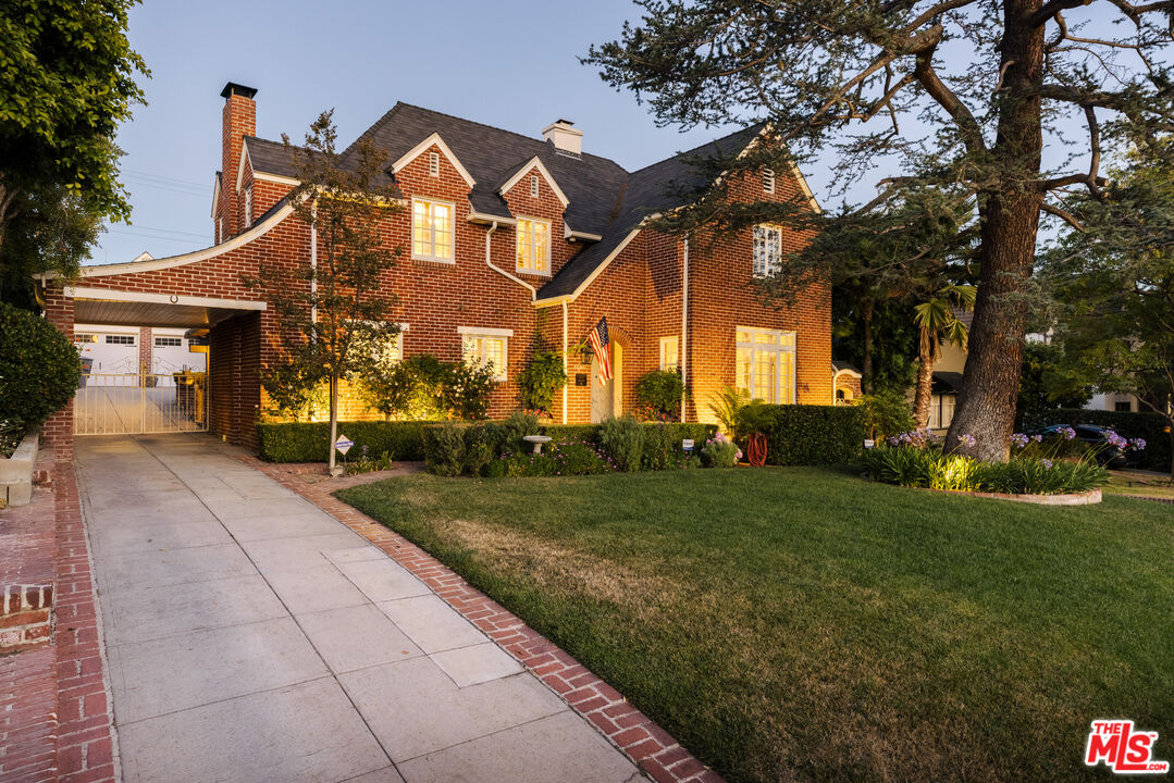 a front view of a house with a yard and trees