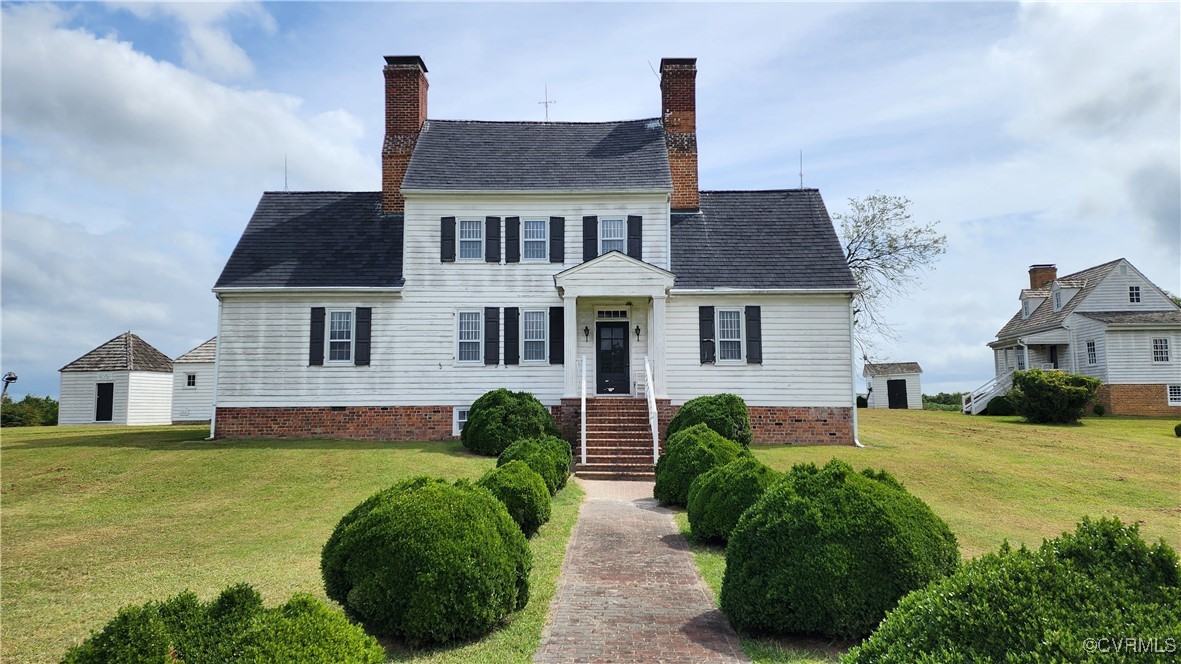 a front view of a house with a garden and plants