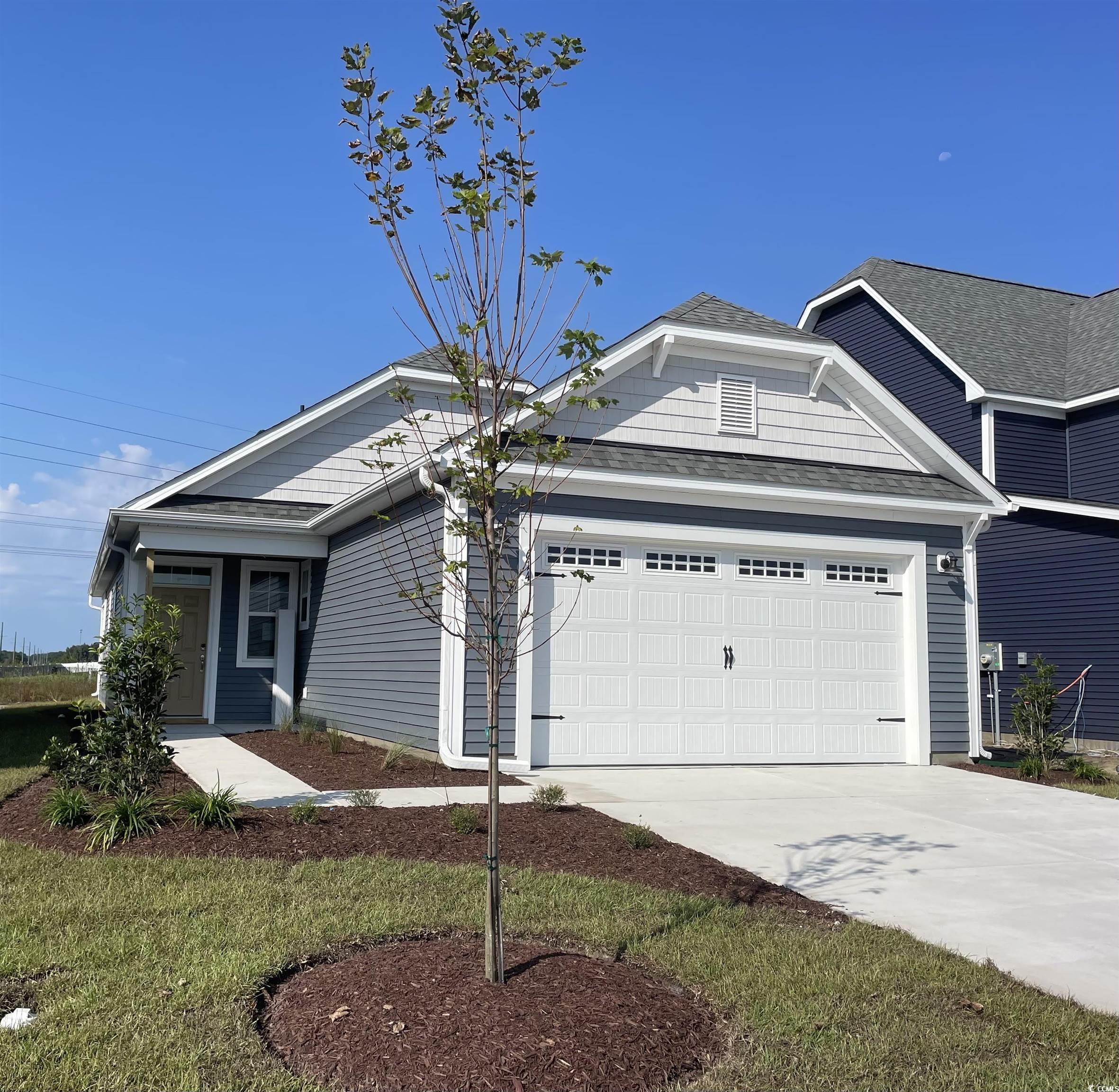 View of front of home with a garage and a front ya