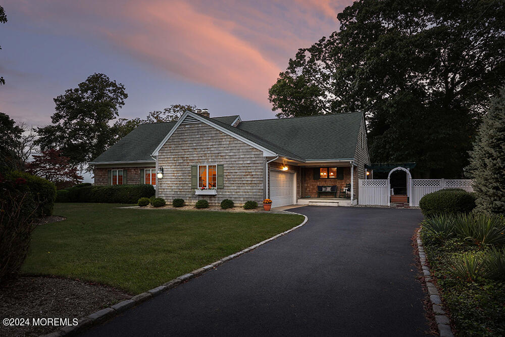 a front view of a house with a garden and tree