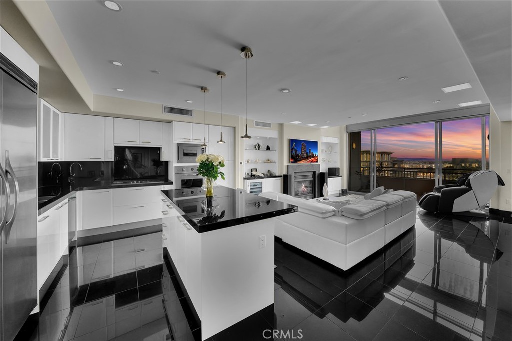 a kitchen with stainless steel appliances granite countertop a table chairs sink and cabinets