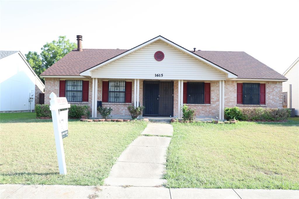 a front view of house with yard and trees around