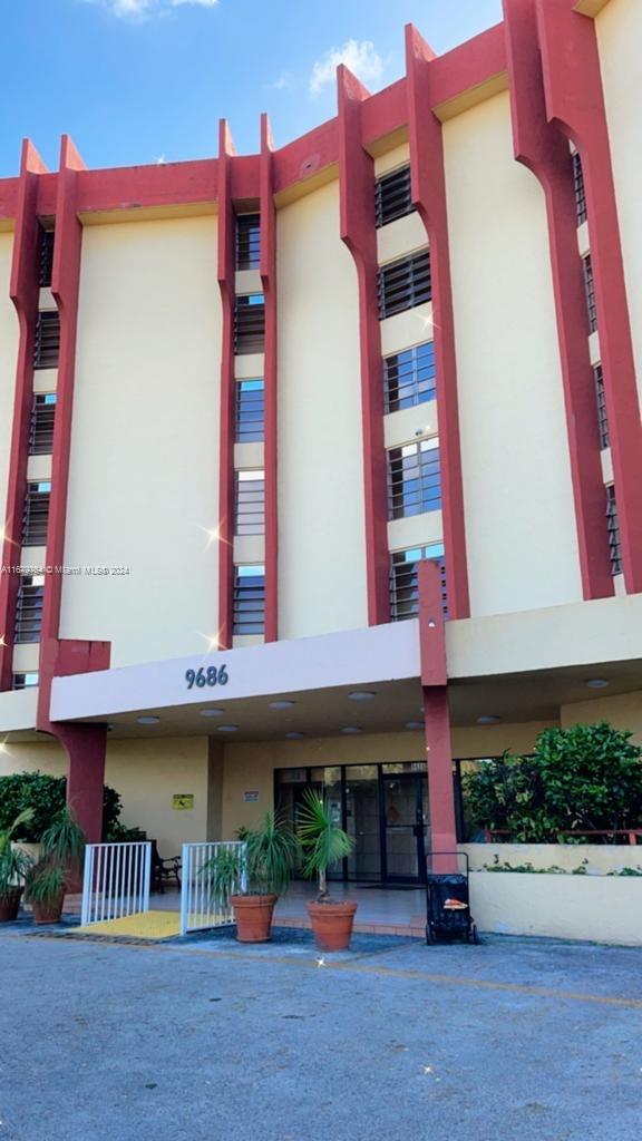 a front view of multi story residential apartment building with yard