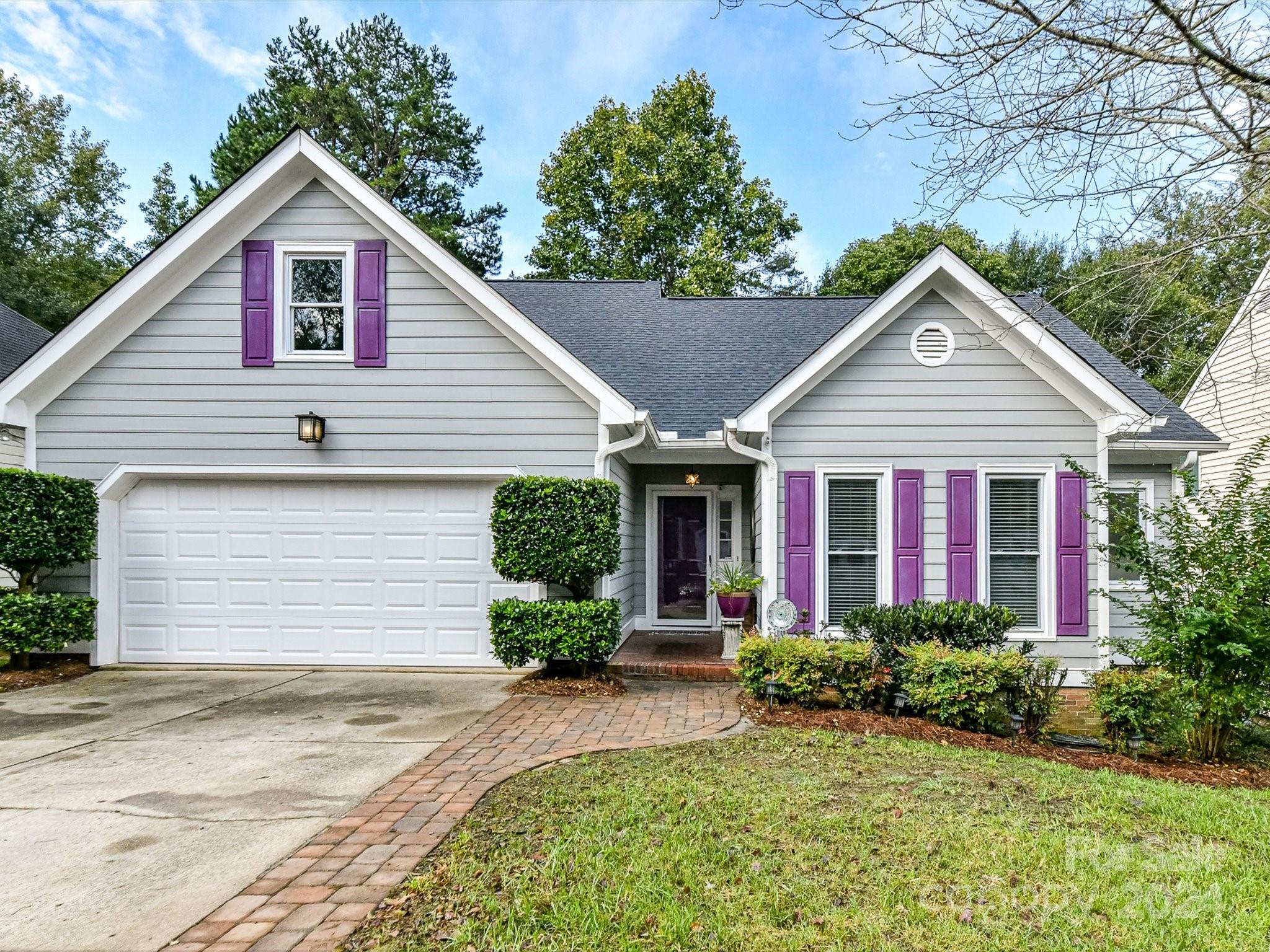 a front view of a house with a yard and potted plants