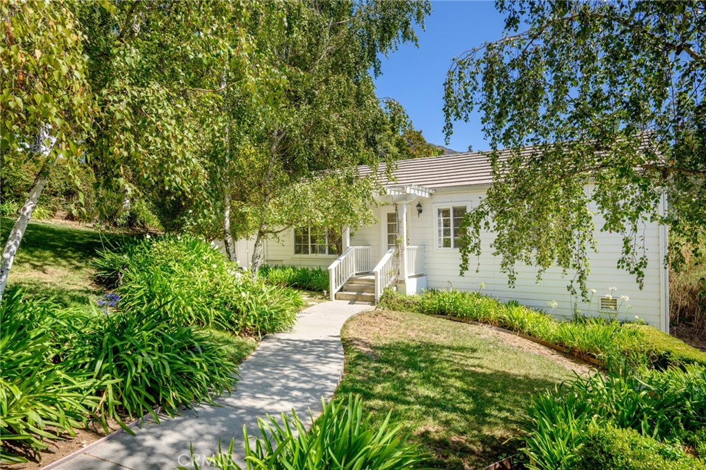 a front view of a house with a yard and trees