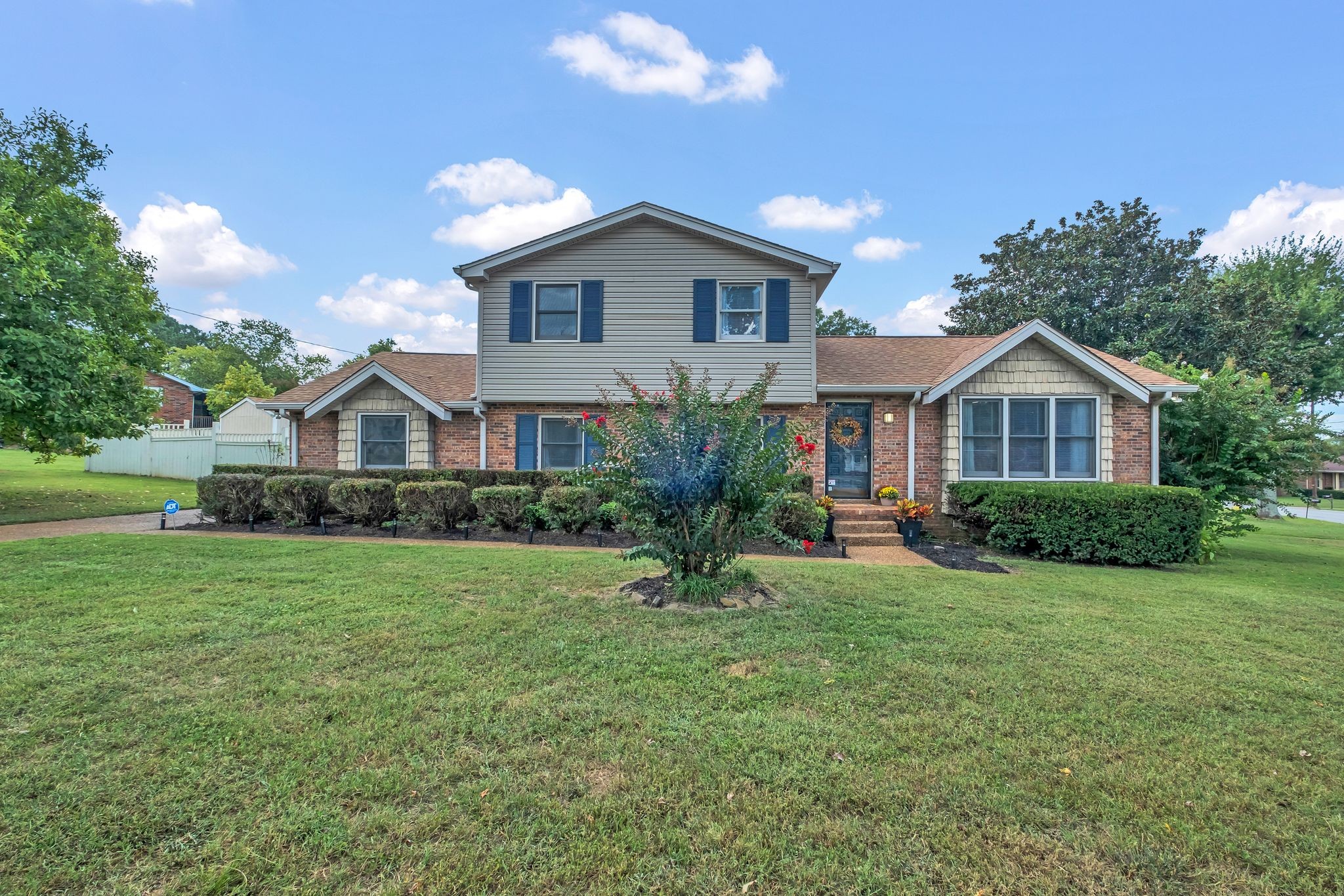 a front view of a house with yard and green space