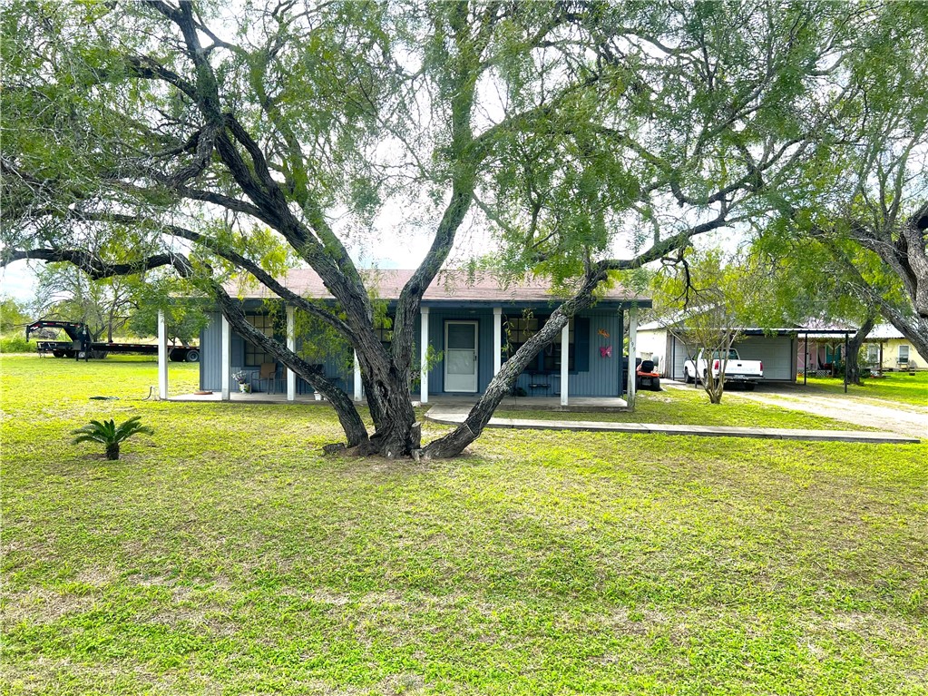 a view of a house with a big yard and large trees