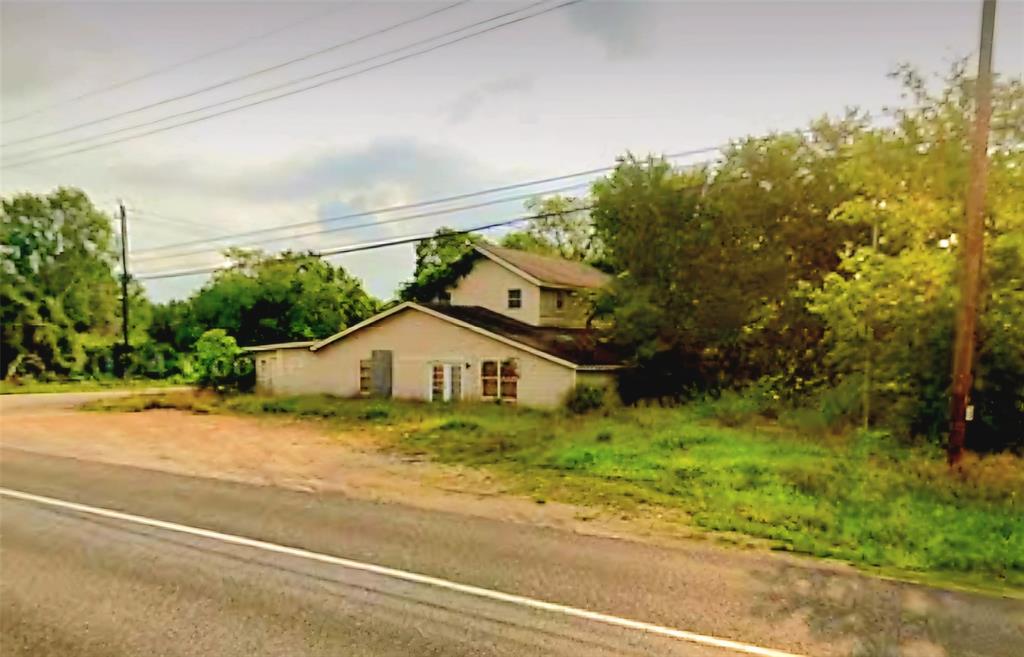 a view of a house with a yard and large trees