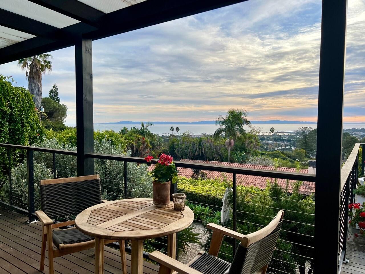 a view of a balcony with chairs and wooden floor