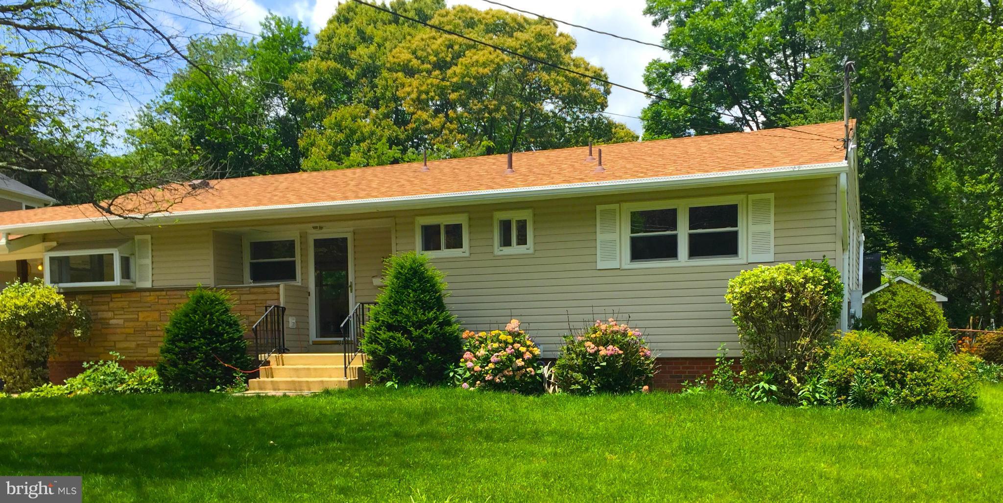 a view of a house with a backyard and a large tree