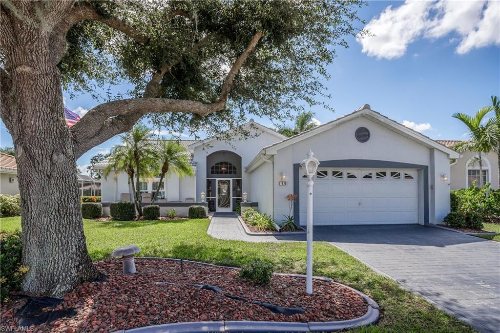 View of front of property with a garage and a front lawn