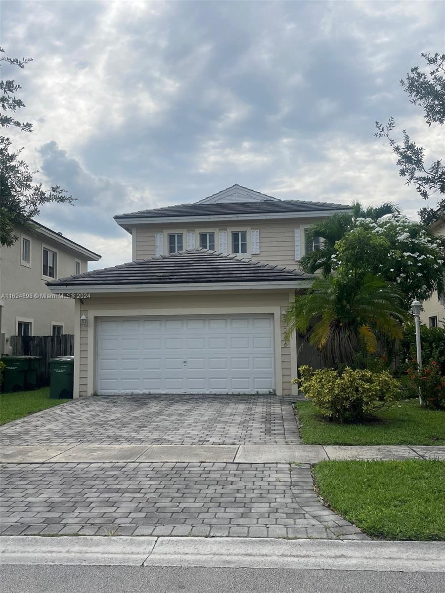 a front view of a house with a yard and garage